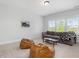 Spacious, naturally-lit room with brown couch, bean bag chairs, and a coffee table, perfect for relaxation at 1824 Amberly Ledge Way, Cary, NC 27519