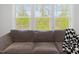 Comfortable living room with a gray sofa and large windows offering serene nature views at 1824 Amberly Ledge Way, Cary, NC 27519