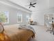 Primary bedroom featuring a tray ceiling, multiple windows, and an open doorway to the ensuite bathroom at 1824 Amberly Ledge Way, Cary, NC 27519