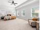 Spacious primary bedroom featuring a tray ceiling, large windows, and a cozy sitting area at 1824 Amberly Ledge Way, Cary, NC 27519