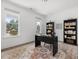 Bright office with large windows, neutral walls, decorative rug, and built-in bookshelves at 1824 Amberly Ledge Way, Cary, NC 27519