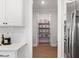 Walk-in pantry with shelving, ideal for organized storage, easily accessible from the kitchen and food preparation areas at 1824 Amberly Ledge Way, Cary, NC 27519