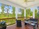 Relaxing porch with wood floors and scenic views of the surrounding trees and lake at 1824 Amberly Ledge Way, Cary, NC 27519