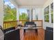 Cozy porch seating area with wooded views and white pillars at 1824 Amberly Ledge Way, Cary, NC 27519