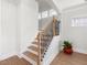View of the staircase with wooden steps and decorative iron railing and bright natural light from the windows at 1824 Amberly Ledge Way, Cary, NC 27519
