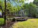 Lovely backyard deck with rock bordered flower bed and a mature tree offers pleasant outdoor retreat at 1846 Forest Wood Rd, Rocky Mount, NC 27804