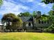 Back of house with a spacious wooden deck overlooking a manicured lawn and garden area; perfect for relaxing at 1846 Forest Wood Rd, Rocky Mount, NC 27804