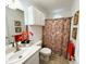 Bright bathroom featuring a colorful shower curtain, vanity, and overhead cabinets at 1846 Forest Wood Rd, Rocky Mount, NC 27804