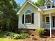 Charming home featuring a unique arched window, brick foundation, and lush landscaping at 1846 Forest Wood Rd, Rocky Mount, NC 27804