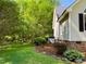 Well-maintained home exterior with lush greenery, a stone-lined flower bed, and manicured lawn at 1846 Forest Wood Rd, Rocky Mount, NC 27804