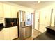 Modern kitchen features stainless steel refrigerator, white cabinets, and a black countertop; functional and stylish at 1846 Forest Wood Rd, Rocky Mount, NC 27804