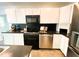Modern kitchen featuring sleek black countertops, stainless steel appliances and pristine white cabinetry at 1846 Forest Wood Rd, Rocky Mount, NC 27804
