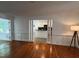 Open living room with hardwood floors and a view into the kitchen with black countertops and white cabinetry at 1846 Forest Wood Rd, Rocky Mount, NC 27804