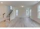 Open living room with a staircase and large windows allowing for plenty of natural light at 2007 Seford Dr, Durham, NC 27703