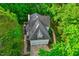 Aerial view of a home with a gray roof, showcasing a brick driveway and lush, mature trees at 201 Johnstone Ct Ct, Durham, NC 27712