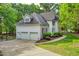 Exterior view of home showcasing a three-car garage and manicured front yard at 201 Johnstone Ct Ct, Durham, NC 27712