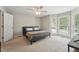This main bedroom has bay windows, a ceiling fan, and neutral-toned walls and carpets at 2028 Ruddy Rd, Raleigh, NC 27616