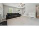 Spacious living room features carpeted floors, ceiling fan, staircase, and a large grey sofa at 2028 Ruddy Rd, Raleigh, NC 27616