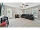 Cozy living room with carpet, fireplace, ceiling fan, and a large grey sofa near the windows at 2028 Ruddy Rd, Raleigh, NC 27616