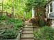 Stone steps leading to backyard surrounded by well-maintained landscaping, offering a tranquil escape into nature at 205 Glenview Pl, Chapel Hill, NC 27514