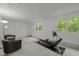 Finished basement featuring two windows, exercise equipment, and comfy seating area at 205 Glenview Pl, Chapel Hill, NC 27514