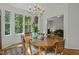 Sunlit dining area with a wood table, chandelier, and beautiful view of the outdoors at 205 Glenview Pl, Chapel Hill, NC 27514