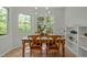 Bright dining room featuring a wooden table, decorative chairs, and views of the surrounding trees at 205 Glenview Pl, Chapel Hill, NC 27514
