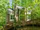 Two-story home featuring brick and siding exterior, surrounded by mature trees, creating a sense of privacy and seclusion at 205 Glenview Pl, Chapel Hill, NC 27514