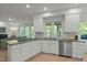 Charming kitchen featuring white cabinets, stainless steel appliances, granite counters, and abundant natural light at 205 Glenview Pl, Chapel Hill, NC 27514
