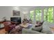 Comfortable living room with a fireplace, plush seating, and views of the lush greenery outside at 205 Glenview Pl, Chapel Hill, NC 27514
