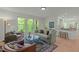 Cozy living room featuring large windows, comfortable seating, and an open layout connecting to the kitchen at 205 Glenview Pl, Chapel Hill, NC 27514