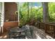 Relaxing outdoor patio area with a metal table and chairs, surrounded by lush greenery and views of the natural landscape at 205 Glenview Pl, Chapel Hill, NC 27514