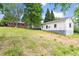 View of the grassy backyard with two buildings on the property, with a blue sky overhead at 209 N Occoneechee St, Hillsborough, NC 27278