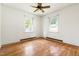 Bright bedroom featuring hardwood floors, white walls, and two windows providing natural light at 209 N Occoneechee St, Hillsborough, NC 27278
