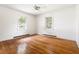 Bright bedroom featuring hardwood floors, white walls, and two windows providing natural light at 209 N Occoneechee St, Hillsborough, NC 27278