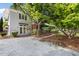 Two-story home with modern design, gravel driveway, and lush landscaping at 209 N Occoneechee St, Hillsborough, NC 27278