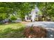 Charming white home with a well-maintained lawn, a detached garage and a gravel driveway at 209 N Occoneechee St, Hillsborough, NC 27278
