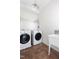 Functional laundry room with washer, dryer, utility sink, and practical storage at 209 N Occoneechee St, Hillsborough, NC 27278
