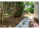 Manicured backyard with stone and gravel walkway surrounded by trees and shrubs at 210 Needle Park Dr, Cary, NC 27513
