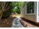 Stone and gravel walkway leads through a verdant backyard with shrubbery at 210 Needle Park Dr, Cary, NC 27513