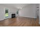 Open living room with fireplace, ceiling fan, patio door, and wood floors at 210 Needle Park Dr, Cary, NC 27513