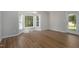 Well-lit living room with hardwood floors, bay window, and a glass patio door at 210 Needle Park Dr, Cary, NC 27513