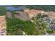 This aerial shows an area with wooded and cleared land, and a neighborhood nearby at 2102 Courtland Dr, Sanford, NC 27330