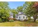 Charming home surrounded by lush greenery, trees, and blooming rose bushes at 2102 Courtland Dr, Sanford, NC 27330