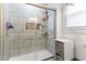 Modern tiled shower featuring glass doors and built-in shelving for toiletries at 2102 Courtland Dr, Sanford, NC 27330
