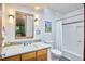 Bathroom features a new vanity, framed mirror, modern lighting, and shower/tub combination with decorative tile accents at 220 Glenhill Ln, Chapel Hill, NC 27514