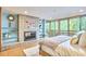 Bedroom with tiled fireplace, shelving, large windows and access to deck at 220 Glenhill Ln, Chapel Hill, NC 27514