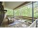 Inviting deck with wood floors, wood railing and outdoor seating among lush trees at 220 Glenhill Ln, Chapel Hill, NC 27514