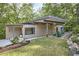 Contemporary home with a flat roof, green lawn, natural landscaping, and outdoor seating area at 220 Glenhill Ln, Chapel Hill, NC 27514