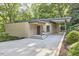 Modern home exterior with a flat roof, carport, and lush landscaping, offering a stylish curb appeal at 220 Glenhill Ln, Chapel Hill, NC 27514